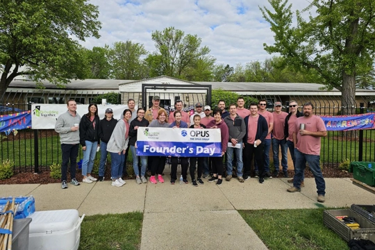 group of people holding a sign with the words "Founder's Day"